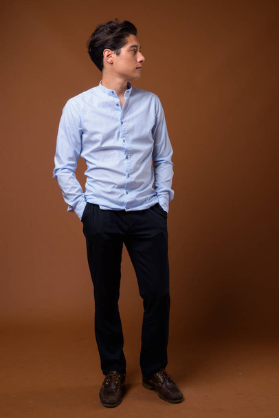 Jeune homme d'affaires multi-ethnique beau sur fond brun
 - Photo, image