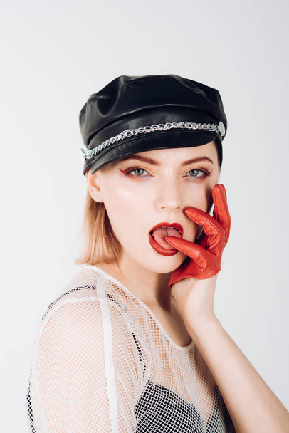 Trendy girl in rock style. girl with fashionable makeup in red gloves and leather cap. - Foto, Imagem