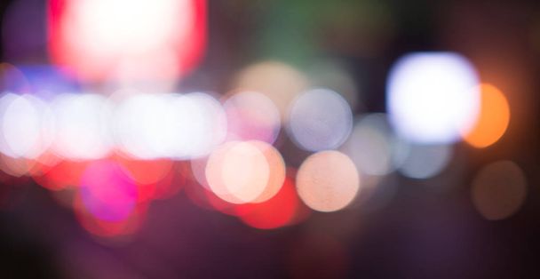 Размытые уличные фонари, городской абстрактный фон. разряженный образ ночного города. Транспортные средства на дороге. - Фото, изображение