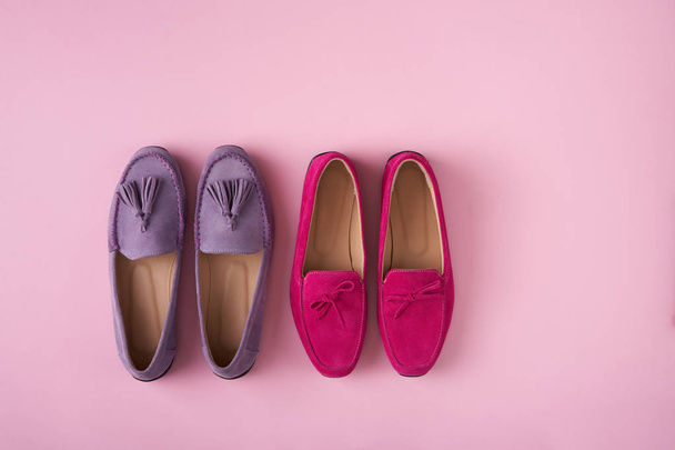 Two pairs of suede moccasins shoes lilac and bright raspberry over pink background - Fotó, kép