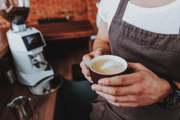Close up of cup of coffee in the hands of male barista - Foto, Imagen