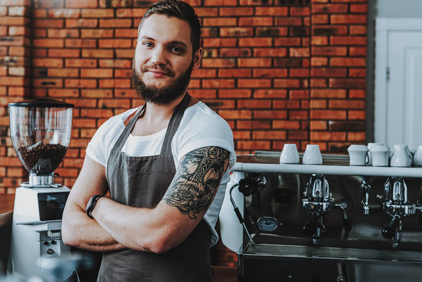 Waist up of cheerful barista standing with arms crossed and smiling - Фото, изображение