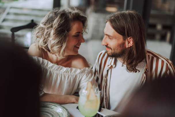 Beautiful couple sitting next to each other in cafe - Photo, image