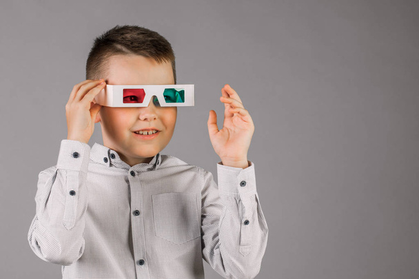 Young handsome boy with 3d glasses on grey background in Studio. - Foto, Imagem