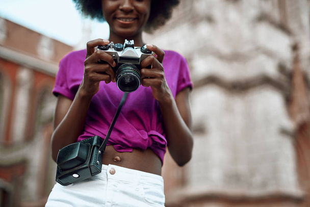Happy young afro-american woman holding retro camera - Fotó, kép