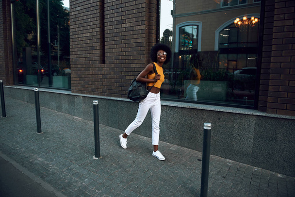 Pretty and smiling afro-american woman walking outside - Foto, Bild