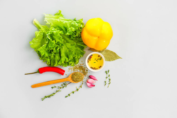 Verse kruiden met groenten, olie en specerijen op grijze achtergrond - Foto, afbeelding