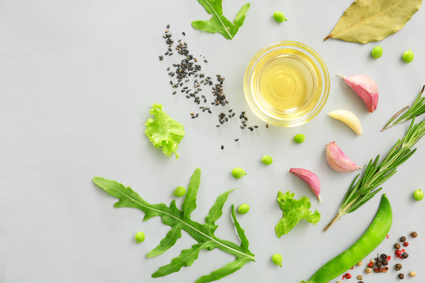 Fresh herbs with vegetables, oil and spices on grey background - Photo, Image