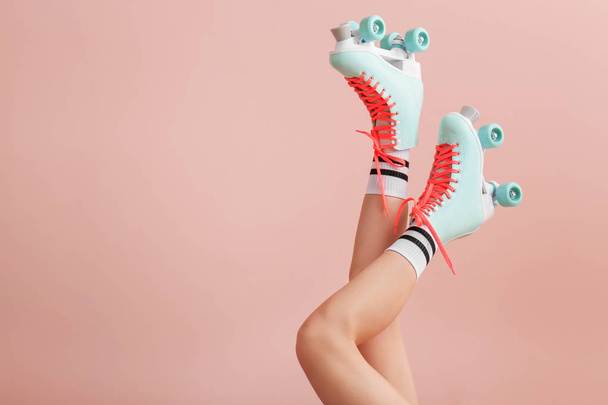 Legs of woman in vintage roller skates on color background - Photo, Image