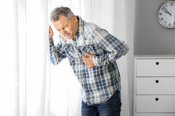 Homme mature souffrant d'une crise cardiaque à la maison
 - Photo, image