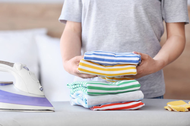 Woman stacking clean clothes at home - Foto, immagini