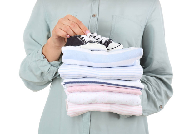 Young woman with stack of clean clothes on white background, closeup - Photo, Image
