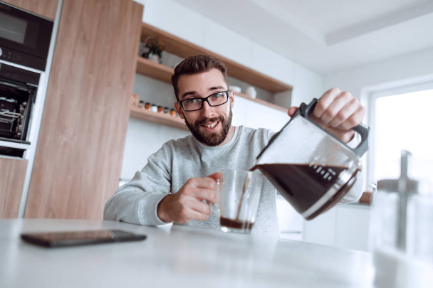 attractive man pours himself a cup of delicious coffee - Fotó, kép
