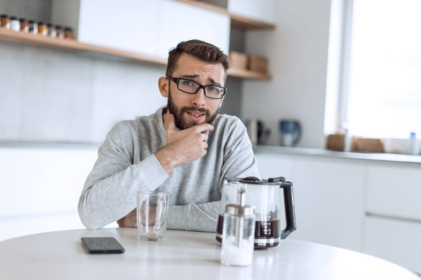 attractive man sitting at the kitchen table in the morning - Photo, image