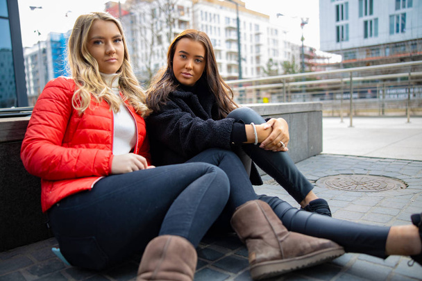 Portrait de deux amies confiantes assises en ville
 - Photo, image