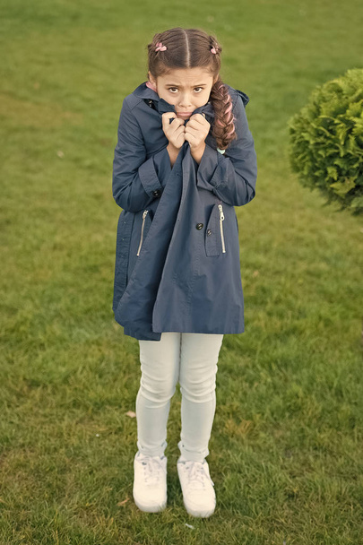Girl cute face braided hair posing coat in spring park. Clothing for spring walks. Little fashion model. Clothes and accessory. Kid wear trench coat. Spring coat. Must have concept. Fashionable coat - Photo, Image