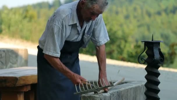 Старший чоловік ремонтує дерев'яні граблі
 - Кадри, відео