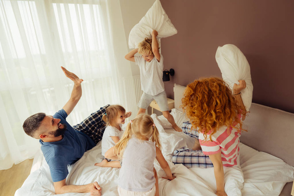 Delighted positive family having a pillow battle - 写真・画像