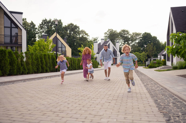 Delighted joyful family running on the street - Zdjęcie, obraz