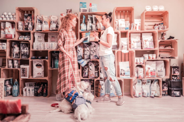 Curly red-haired woman with two dogs coming to pet shop - Fotoğraf, Görsel