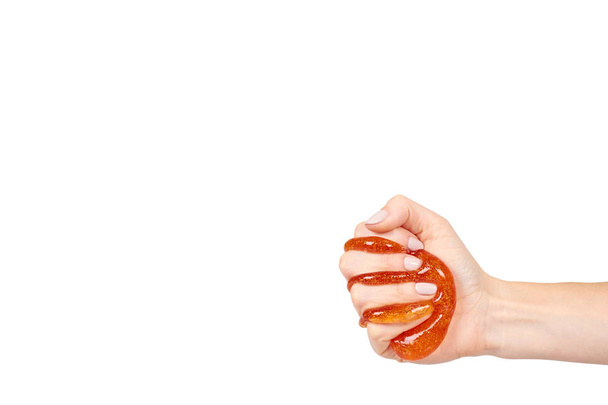 kid playing orange slime with hand, transparent toy - Foto, Imagem