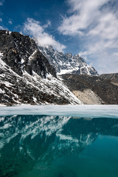Berge spiegeln sich in teilweise zugefrorenem See - Foto, Bild