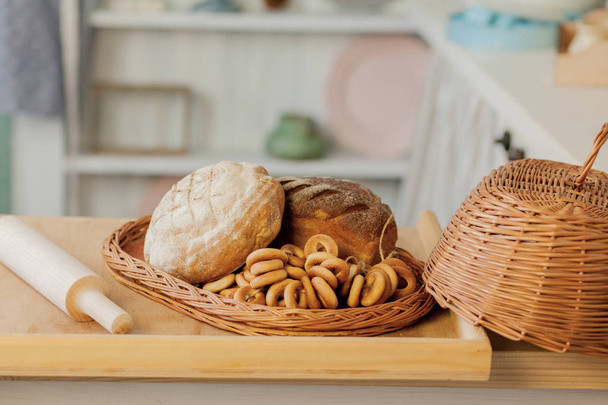 Assortment of breads near a wicker basket on a table in a rustic - Foto, imagen