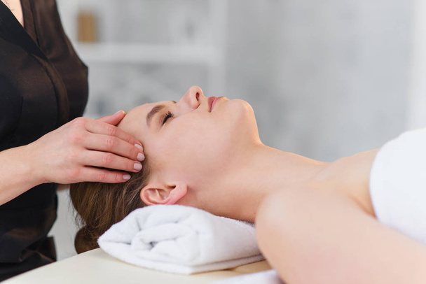 Young masseur making massage for young female client. - Fotó, kép