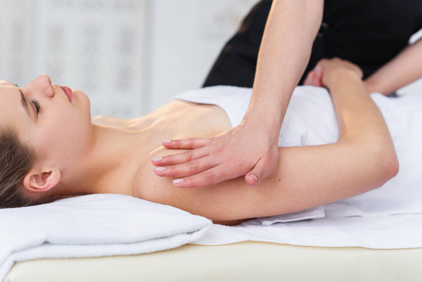 Young female masseur making massage in spa salon. - Foto, immagini
