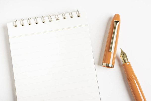 Oranžové plnicí pero s notebookem vázaným na spirálu - Fotografie, Obrázek