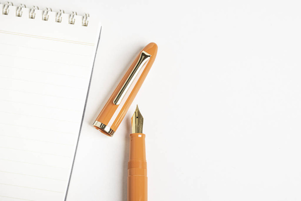 Oranžové plnicí pero s notebookem vázaným na spirálu - Fotografie, Obrázek