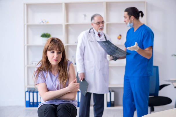 Two doctors examining young woman  - Foto, Imagem