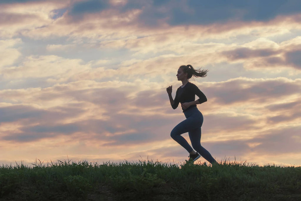 実行中の女性の朝のトレーニング。女性ランナー。太陽の中にジョギング - 写真・画像