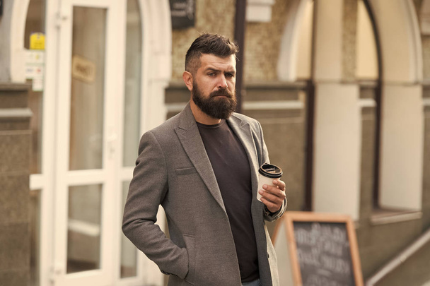 Make this day with coffee. Bearded man enjoying morning coffee. Drinking his cup first thing in morning. Businessman in hipster style holding takeaway coffee. Hipster with paper cup walking in city - Foto, immagini