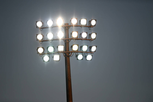 Torre di luce dello stadio sportivo durante la notte, contro un cielo buio
. - Foto, immagini
