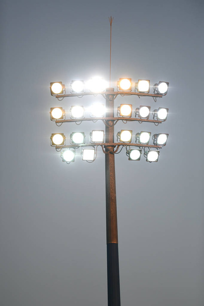 Estádio esportivo torre de luz durante a noite, contra um céu escuro
. - Foto, Imagem