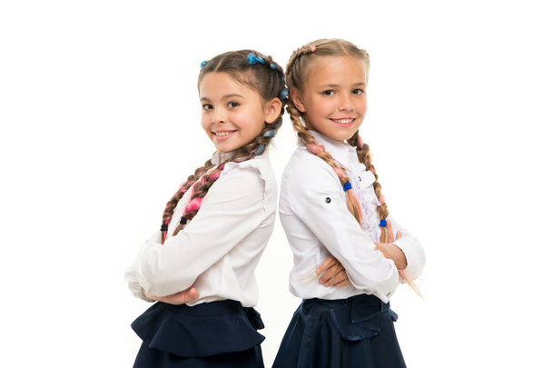 Cute but smart. Adorable little girls smiling isolated on white. Happy small girls wearing school uniform. Primary school girls with plaited hair in long braids. Adorable girls proud being classmates - Valokuva, kuva