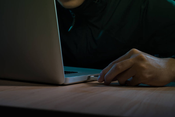 Homme travaillant sur un ordinateur portable dans une pièce sombre
 - Photo, image