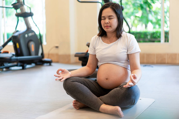 Active pregnant woman exercise in fitness center. - Photo, Image