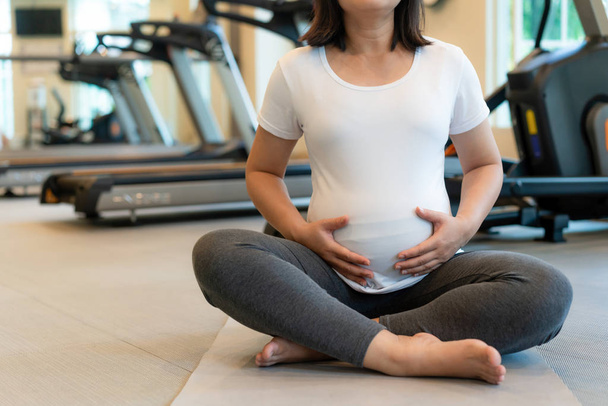 Aktív terhes nő testmozgás fitneszteremben. - Fotó, kép