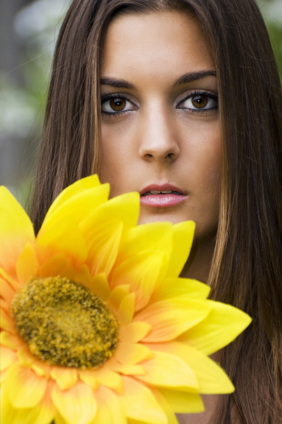 Portret van vrouw met gele bloem - Foto, afbeelding
