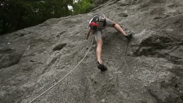 jonge man klimmen op een grote rots in de natuur - Video