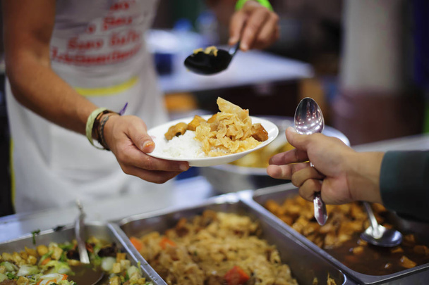 Pessoas sem-teto e pessoas famintas se alinham, pedindo comida gratuita de voluntários
. - Foto, Imagem