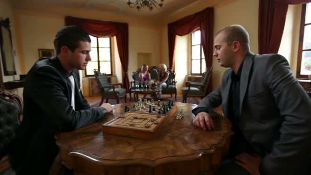 Kaksi liikemiestä pelaamassa shakkia vanhanaikaisessa ravintolassa.
 - Materiaali, video