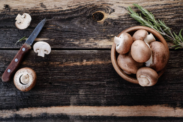 Brown mushrooms on old dark wooden background - Foto, imagen