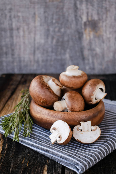 Brown mushrooms on old dark wooden background - Foto, imagen