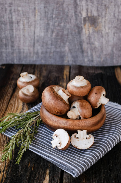 Brown mushrooms on old dark wooden background - Fotó, kép