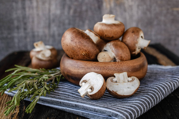 Brown mushrooms on old dark wooden background - 写真・画像