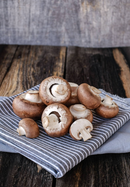 Brown mushrooms on old dark wooden background - Фото, изображение