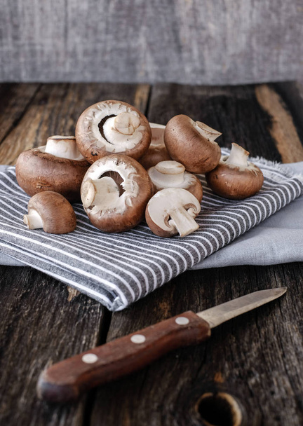 Brown mushrooms on old dark wooden background - Φωτογραφία, εικόνα